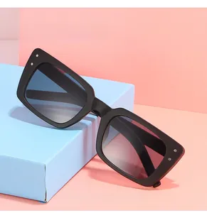Détail des lunettes de soleil rectangulaires noires avec rivets et verres dégradés