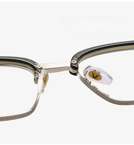 Detail of metal glasses bridge and clear silicone nose pads with gold V-shaped logo