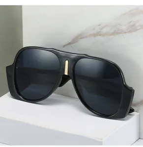 Detail view of large pilot sunglasses with glossy black frame and gold metal nose bridge