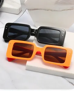 Close-up of black and orange square frame computer safety glasses with silver rivet details