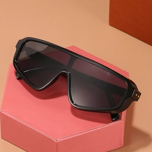 Oversized fashion shield sunglasses in black frame with gold dot accents on pink display