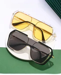 Detail view of large square frame sunglasses with yellow and grey lenses on white stone