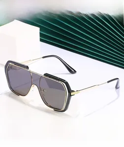 Detail showing the black and gold frame of the modern oversized square sunglasses