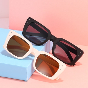 Lunettes de soleil rectangulaires rétro avec rivets sur socles géométriques bleus