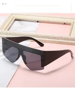 Detail shot of oversized flat top sunglasses with thick temples on marble background