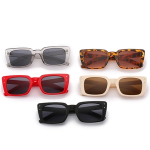 Lunettes de soleil rectangulaires avec rivets en plusieurs couleurs sur fond blanc