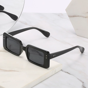 Classic retro square black sunglasses with silver rivet accents on a marble background