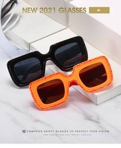 Détail de lunettes de soleil carrées noires et écaille sur un support en marbre