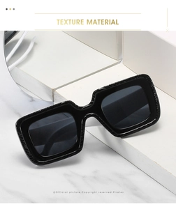 Détail des lunettes de soleil carrées noires avec branches texturées et charnières robustes