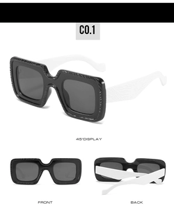 Détail de lunettes de soleil carrées avec branches larges texturées en noir et blanc