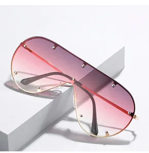 Detail der übergroßen Flat-Top-Sonnenbrille mit rosa Verlaufsgläsern und Metallnieten