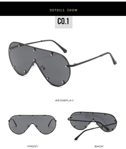 Detailsicht der Oversize-Schild-Sonnenbrille mit Silbernieten und grauen Gläsern