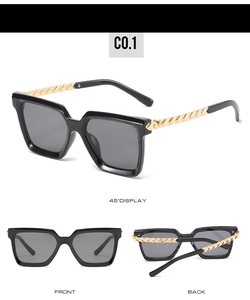 Macro detail of oversized square sunglasses featuring unique gold chain texture metal temples