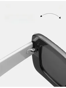 Détail des charnières métalliques renforcées sur les lunettes de soleil carrées noires