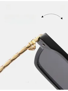 Detail of durable textured gold metal hinge on oversized black square sunglasses
