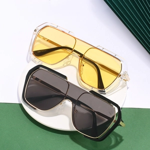 Flat top oversized square sunglasses in yellow and black on a white stone pedestal