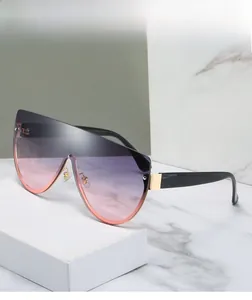 Détail de lunettes de soleil masque oversize avec verres dégradés et accents dorés