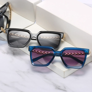 Stylish square frame sunglasses with metal chain temples on minimalist marble pedestals