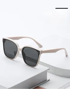 Occhiali da sole squadrati oversize crema su gradini bianchi con lenti anti-UV scure