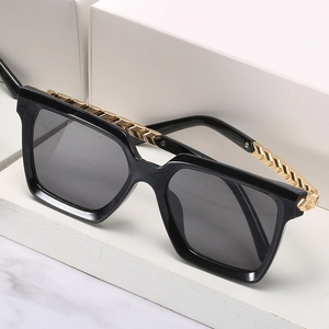 Women's oversized square sunglasses with gold chain trim and grey lenses on white block