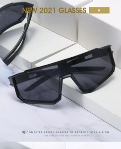 Detail view of large matte black safety glasses with protective grey lenses on marble