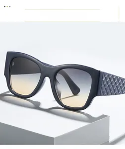 Detail of dark blue square sunglasses featuring checkered embossed temples and gradient lenses