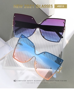 Détail de lunettes de soleil sans monture dégradées avec rivets et charnières dorées
