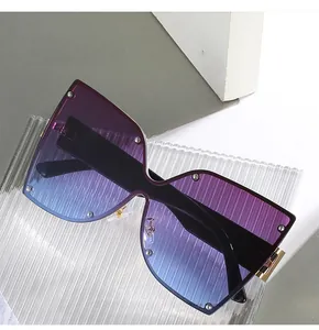Détail de lunettes de soleil papillon sans monture avec verres dégradés violets et clous