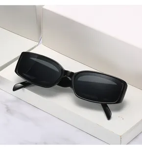 Détail de lunettes de soleil rectangulaires noir brillant sur un présentoir géométrique
