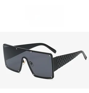 Détails de lunettes de soleil noires avec rivets argentés et branches à motif matelassé