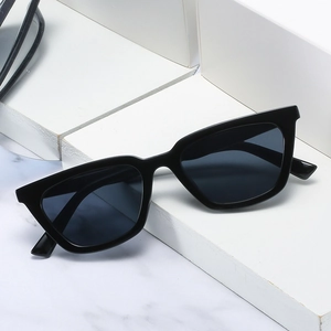 Classic retro black cat-eye sunglasses for women with glossy frames on white geometric steps