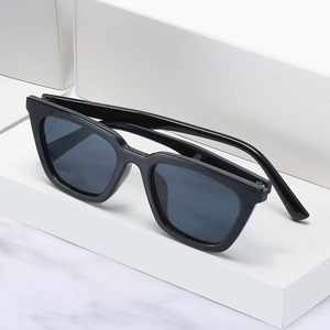 Classic black cat-eye sunglasses with glossy frames on white minimalist pedestals