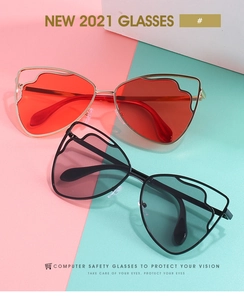 Close-up of geometric wave frames in cat-eye sunglasses with gold and black finish