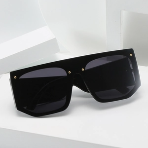 Oversized flat top sunglasses with black lenses and decorative gold rivet details