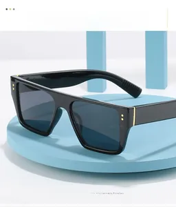 Detail showing black flat top square sunglasses with decorative gold dot rivets