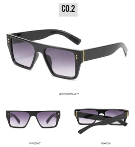 Detail view of square black sunglasses with golden studs and purple gradient lenses