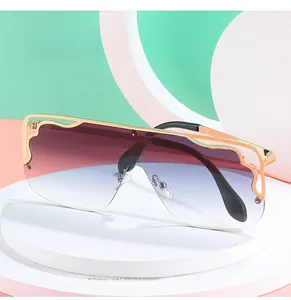 Detail of oversized flat top sunglasses with gradient purple lenses and gold hollow metal frame