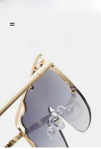 Detail of gold metal hinge and hollowed-out temple design on oversized sunglasses
