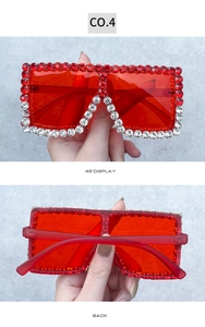 Detail of red oversized square sunglasses featuring dense rhinestone embellishments