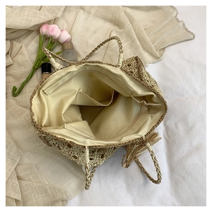 Interior view of beige woven tote bag showing fabric lining and zipper pocket