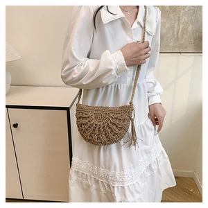 Detailed straw shoulder bag with hollow weaving pattern and decorative tassels for summer