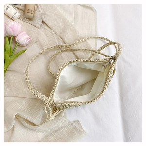 Detail view of woven straw crossbody bag with metal zipper and soft fabric lining