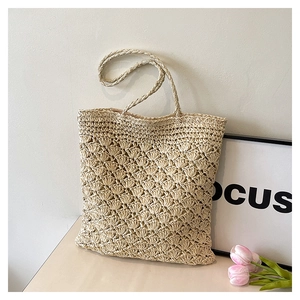 Detailed close-up of handmade crochet weave texture on beige straw tote bag