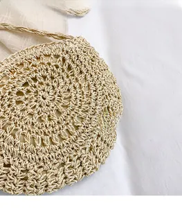 Detailed view of the intricate hand-woven hollow crochet texture on the beige summer bag