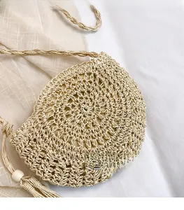 Detail of handmade woven straw bag with raffia texture and elegant tassel charms