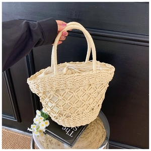 Detail of woven straw handbag with drawstring lining and decorative hollow mesh design