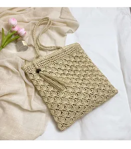 Detail of woven straw shoulder bag with scalloped texture and decorative tassels