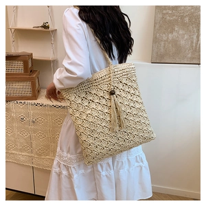 Detailed close-up of bohemian woven shoulder bag with intricate crochet patterns and tassels