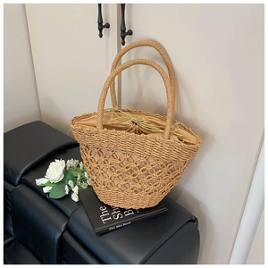 Detail view of woven straw bag with crochet hollow patterns and a beige drawstring pouch