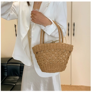 Detail of handmade khaki woven straw tote bag with hollow crochet design and drawstring liner